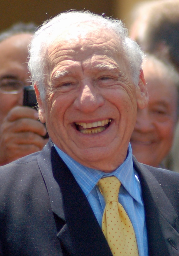 A man in a suit smiles for a photo.