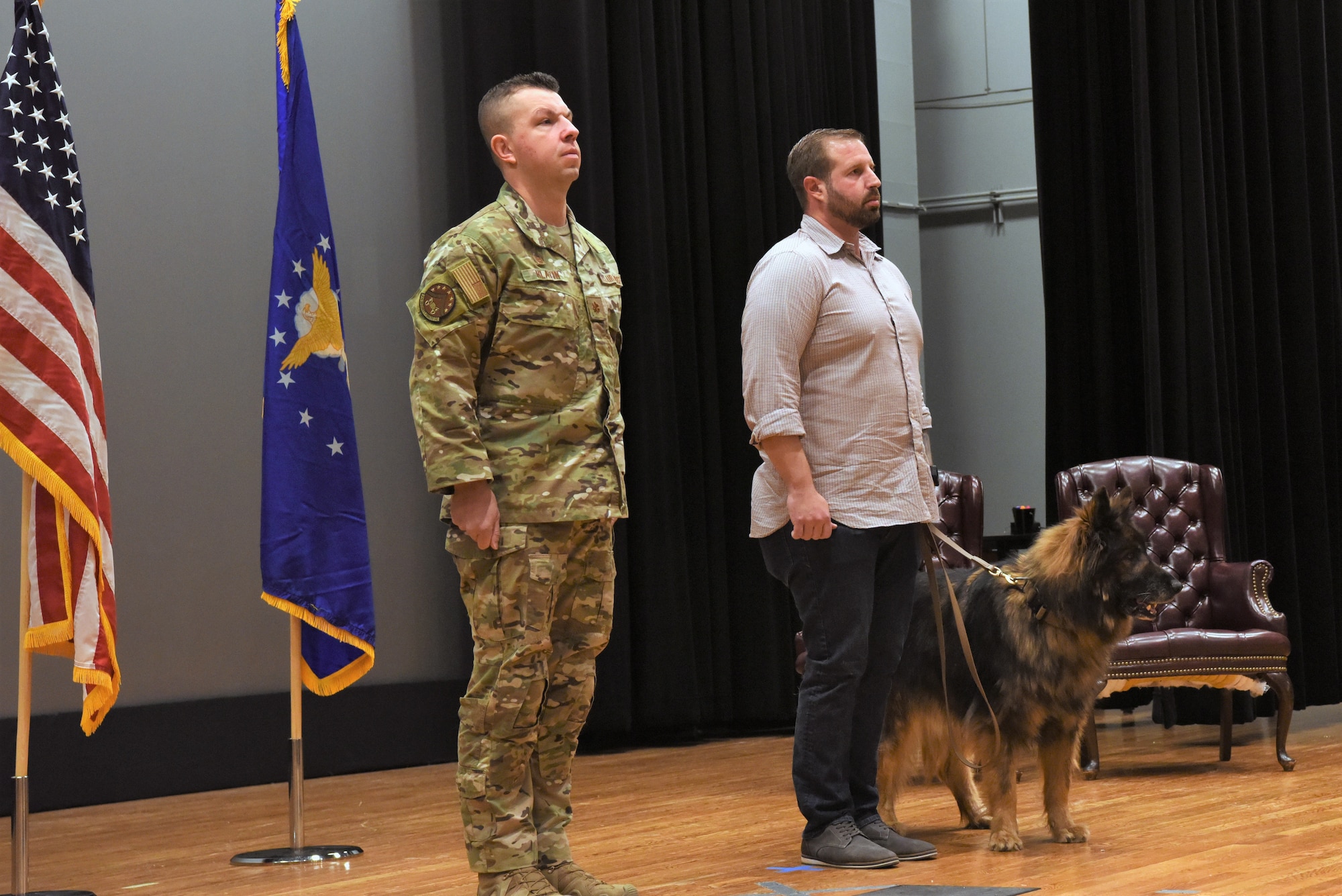 Major Scott Hlavin, 7th Security Forces Squadron commander, left, and Rafael Rhodes, former working dog handler, stand with Nero, 7th SFS military working dog, during the retirement order recitation at Dyess Air Force Base, Texas, Dec. 22, 2021