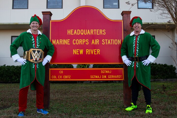U.S. Marine Corps Col. Curtis V. Ebitz, left, commanding officer of Marine Corps Air Station New River, and Sgt. Maj. Douglas W. Gerhardt, right, sergeant major of MCAS New River, stand in front of the MCAS New River headquarters sign before a unit holiday run, on MCAS New River in Jacksonville, North Carolina, Dec. 17, 2021.