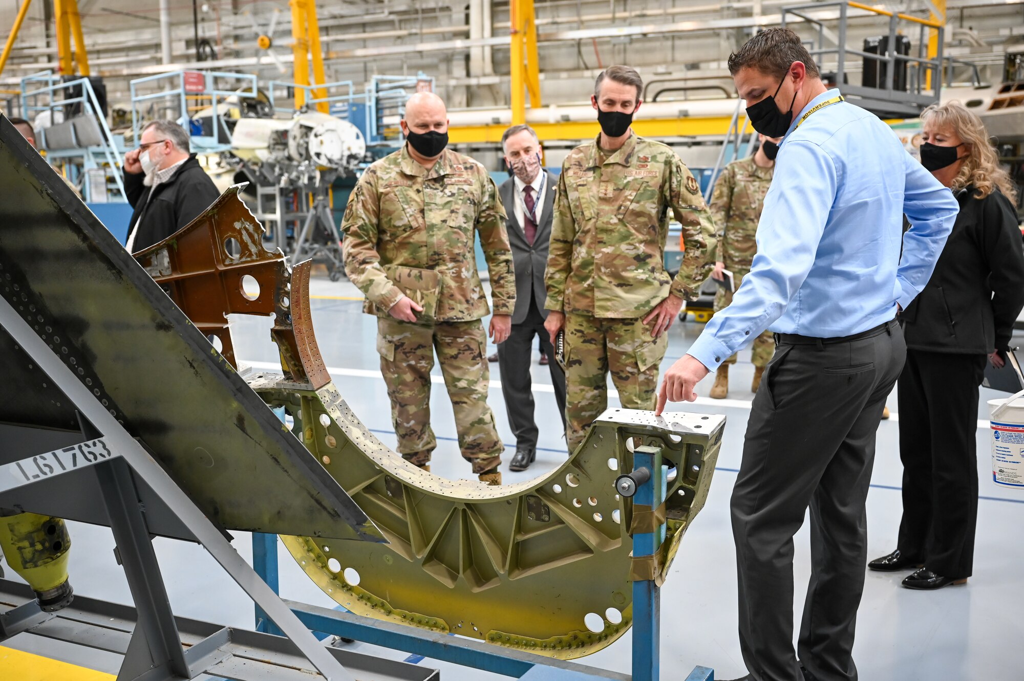 Right) Braden Stander, 573rd Aircraft Maintenance Squadron, briefs Lt. Gen. Tom D. Miller, Air Force Sustainment Center commander, and Chief Master Sgt. Robert C. Schultz, AFSC command chief, about F-16 production.