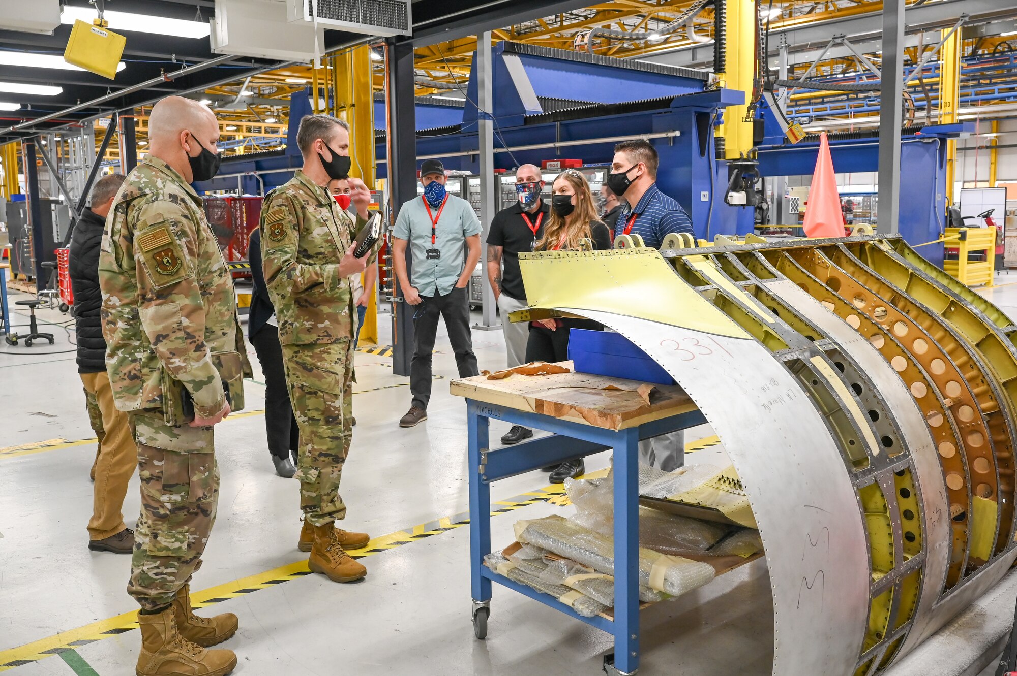 (From left) Chief Master Sgt. Robert C. Schultz, Air Force Sustainment Center command chief, and Lt. Gen. Tom D. Miller, AFSC commander, listen to Alexis Berry, 533rd Commodities Maintenance Squadron director of operations, and Andrew Davis, 533rd CMMXS, during a visit to the A-10 nacelle production depot.