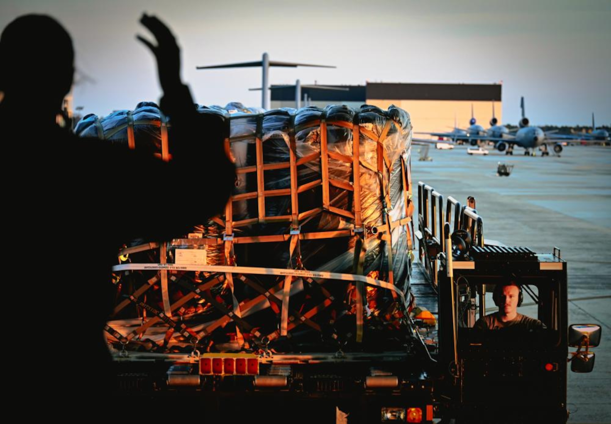 A member of the 305th Aerial Port Squadron guides cargo to be loaded on a C-5M Super Galaxy
