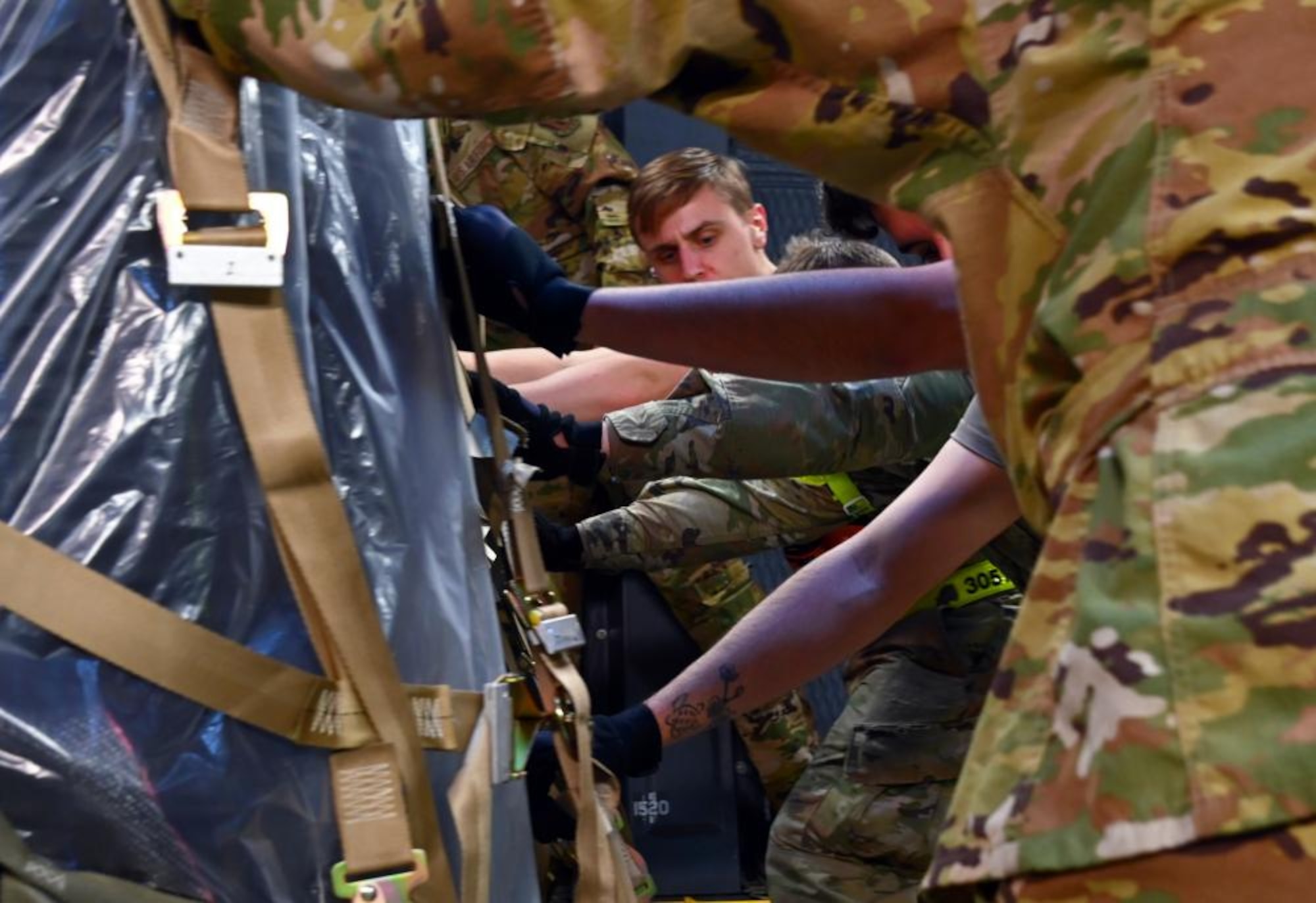 305th Aerial Port Squadron Airmen push a pallet of industrial-grade water filtration equipment onto a C-5M Super Galaxy