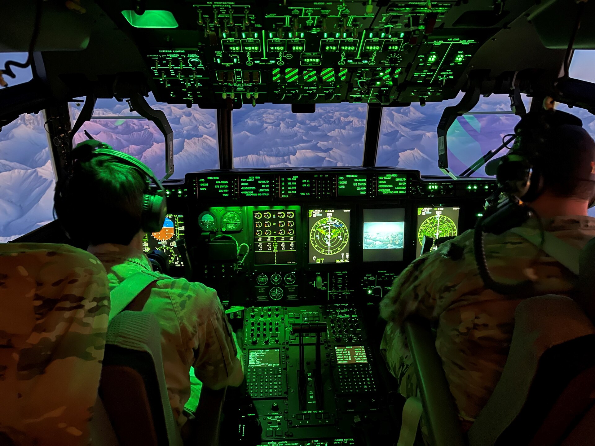 Capt. Trevor Bunkers, left, and Maj. Brandon Burns, right, both pilots assigned to 211th Rescue Squadron fly an HC-130J Combat King II aircraft en route to Joint Base Elmendorf-Richardson, Alaska from Nome, Dec. 2, 2021. Arctic Guardians of 176th Wing helped transport gifts to Bethel and Nome for further delivery to the villages of Chevak and Buckland, respectively, for Operation Santa Claus 2021. Op Santa is an Alaska National Guard annual community outreach program that provides gifts, books, school supplies and stocking stuffers to children in rural Alaskan communities. This year marks the 66th year of the program, which began in 1956 after the village of St. Mary's experienced a year of hardship and the Alaska Air National Guard flew in gifts and supplies donated by the local community. The Alaska National Guard was able to continue the tradition this year and safely provide gifts despite COVID-19. (U.S. Army National Guard photo by Dana Rosso/Released).