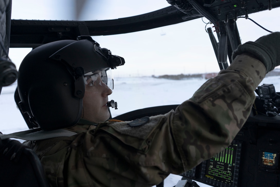 Chief Warrent Officer 3 Ross Wise, pilot, Alaska Army National Guard, B Company, 2-211th General Support Aviation Battalion, flies a CH-47 Chinook helicopter loaded with pallets of Christmas gifts to the children of Buckland as part of Operation Santa Claus 2021. The gifts were delivered to Nome on an HC-130J Combat King II, transferred to the helicopter and flow the rest of the way to be offloaded by Alaska Army National Guard aircrew. Op Santa is an Alaska National Guard annual community outreach program that provides Christmas gifts, books, school supplies and stocking stuffers to children in rural Alaskan communities. This year marks the 65th year of the program, which began in 1956 after the village of St. Mary's experienced a year of hardship and the Alaska Air National Guard flew in gifts and supplies donated by the local community. The Alaska National Guard was able to continue the tradition this year and safely provide gifts despite COVID-19. (U.S. Air National Guard photo by Maj. Chelsea Aspelund/Released).