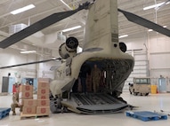 Chief Warrant Officer 3 Ross Wise and Chief Warrant Officer 3 Seth Dibble, Alaka Army Natiolal Guard, B Company, 2-211 General Support Aviation Battalion, help load pallets of gifts Dec. 13, 2021 at Nome onto a CH-47 Chinook helicopter in preparation for delivery to Buckland as part of Operation Santa Claus 2021. Op Santa is an Alaska National Guard annual community outreach program that provides Christmas gifts, books, school supplies and stocking stuffers to children in rural Alaskan communities. This year marks the 66th year of the program, which began in 1956 after the village of St. Mary's experienced a year of hardship and the Alaska Air National Guard flew in gifts and supplies donated by the local community. The Alaska National Guard was able to continue the tradition this year and safely provide gifts despite COVID-19. (U.S. Air National Guard photo by Maj. Chelsea Aspelund/Released).