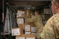 Alaska Army National Guard Capt. Andrew Adams and Chief Warrant Officer 2 Bryan Kruse load pallets of gifts onto an UH-60 Black Hawk helicopter Dec. 13 at the Army Aviation Facility in Bethel, for further delivery to Chevak as part of Operation Santa Claus 2021. Op Santa is an Alaska National Guard annual community outreach program that provides Christmas gifts, books, school supplies and stocking stuffers to children in rural Alaskan communities. This year marks the 65th year of the program, which began in 1956 after the village of St. Mary's experienced a year of hardship and the Alaska Air National Guard flew in gifts and supplies donated by the local community. The Alaska National Guard was able to continue the tradition this year and safely provide gifts despite COVID-19. (U.S. Army National Guard photo by Spc. Grace Nechanicky).