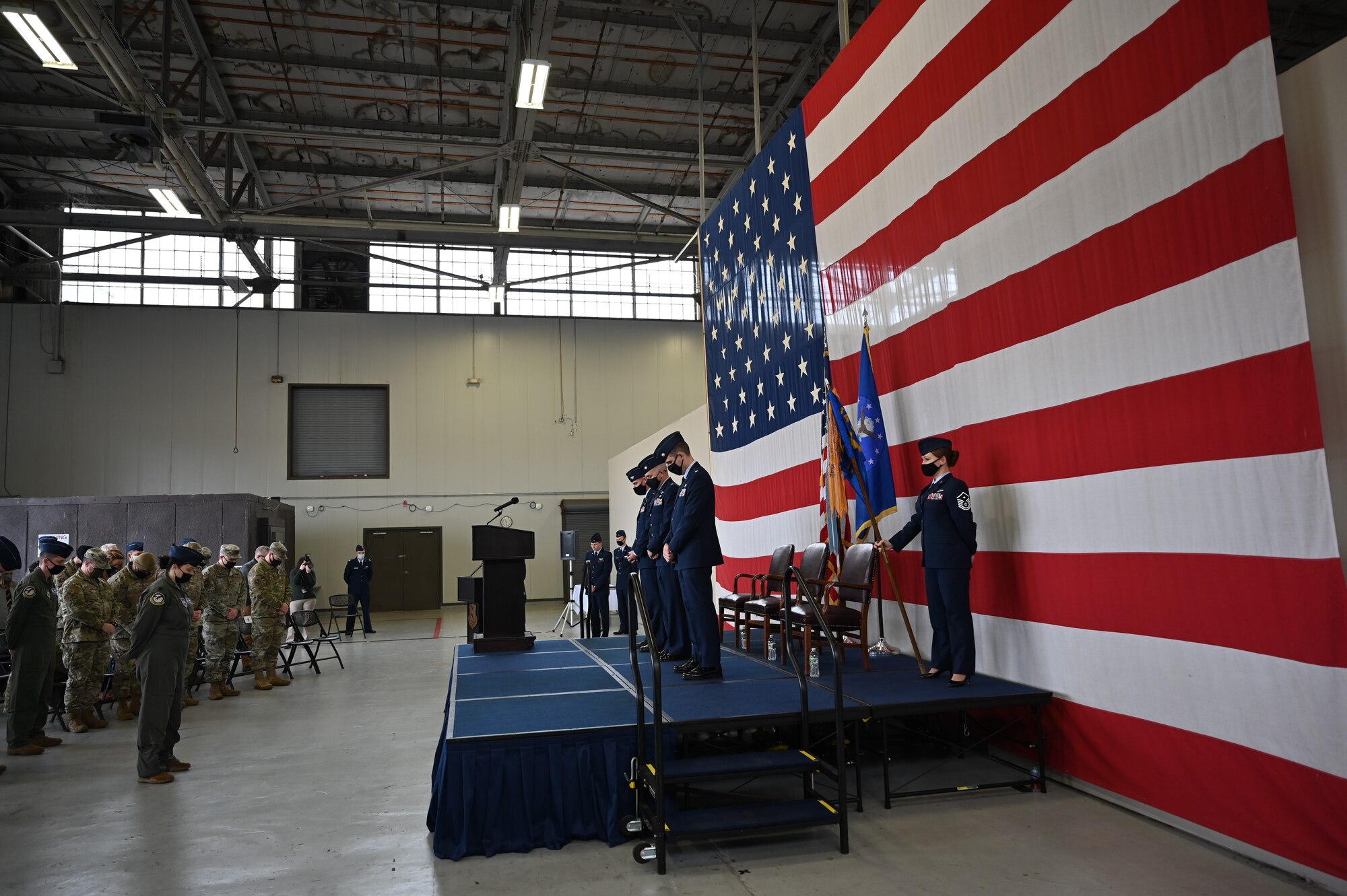 Attendants of the 41st Flying Training Squadron change of command bow their heads in prayer in the Walker Center Dec. 20, 2021, on Columbus Air Force Base, Miss. The formal change of command ceremony allowed troops the opportunity to witness the proceedings and see their new commander take charge. (U.S. Air Force photo by 2nd Lt. Payton Craven)