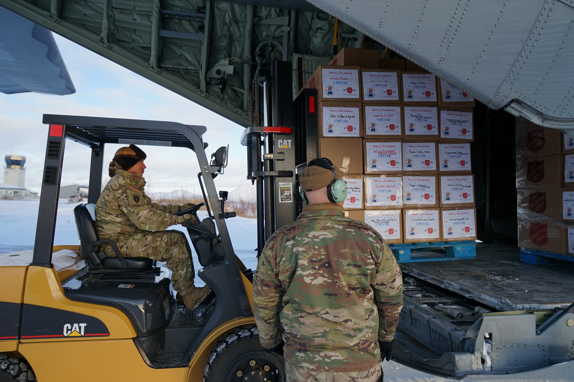 Sgt. Randell Andrew, an armory attendant in Bethel assigned to B Company, 1st Battalion, 297th Infantry Regiment, and Tech. Sgt. Michael Cashman, loadmaster assigned to 211th Rescue Squadron, unload pallets of gifts from an HC-130J Combat King II aircraft Dec. 2, 2021, at Bethel, Alaska, before they are loaded onto an UH-60L Black Hawk helicopter for further delivery to Chevak as part of Operation Santa Claus 2021. Op Santa is an Alaska National Guard annual community outreach program that provides gifts, books, school supplies and stocking stuffers to children in rural Alaskan communities. This year marks the 66th year of the program, which began in 1956 after the village of St. Mary's experienced a year of hardship and the Alaska Air National Guard flew in gifts and supplies donated by the local community. The Alaska National Guard was able to continue the tradition this year and safely provide gifts despite COVID-19. (U.S. Army National Guard photo by Dana Rosso/Released).