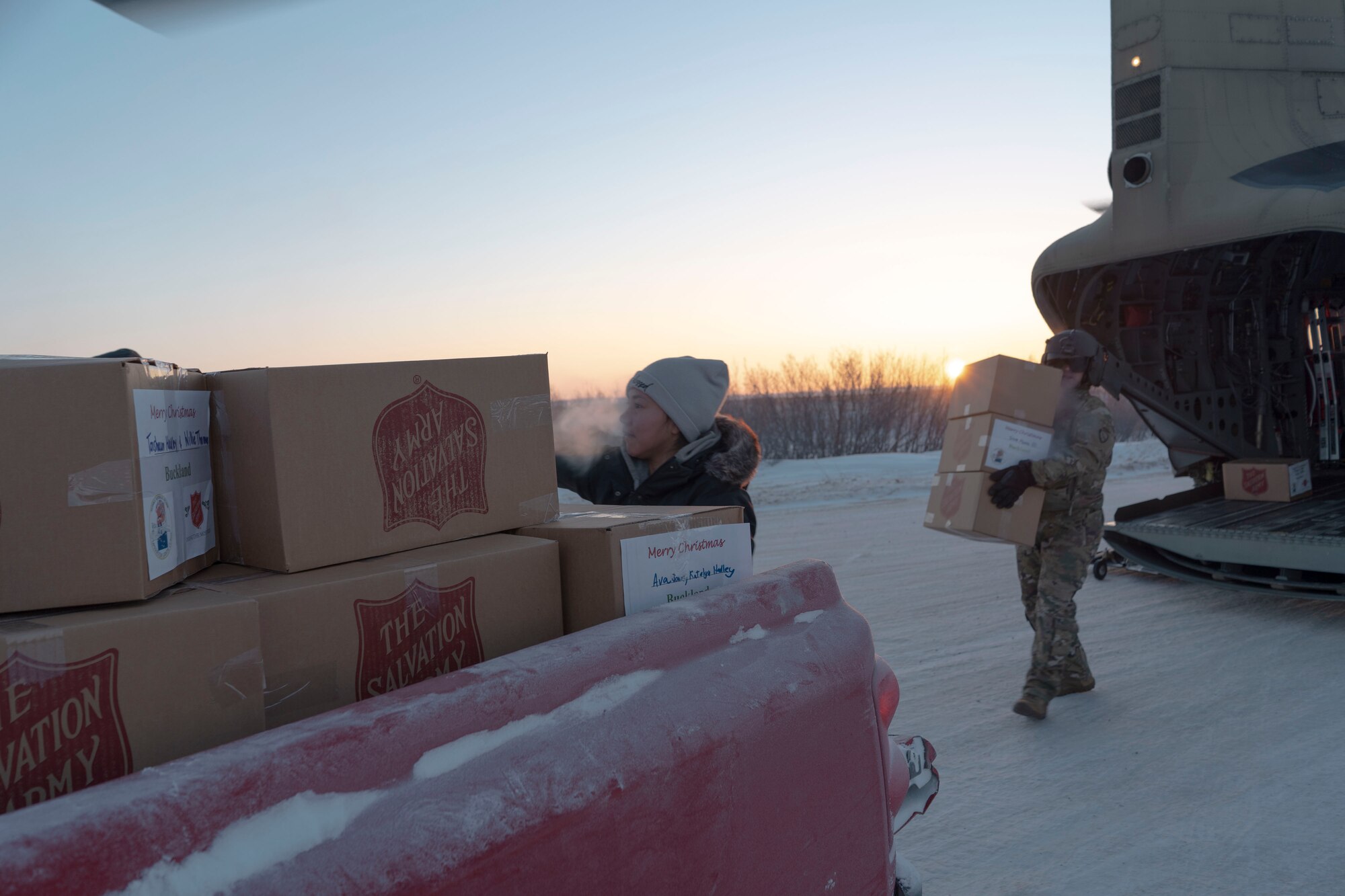 Residents team up with Alaska Army National Guard soldiers to unload two hundred sixety-one gift packages from a CH-47 Chinook helicopter in Buckland, Alaska during Operation Santa Claus, Dec. 14, 2021. Operation Santa Claus is an Alaska National Guard annual community outreach program that provides Christmas gifts, books, school supplies and stocking stuffers to children in rural Alaskan communities. This year marks the 66th year of the program, which began in 1956 after the village of St. Mary's experienced a year of hardship and the Alaska Air National Guard flew in gifts and supplies donated by the local community. The Alaska National Guard was able to continue the tradition this year and safely provide gifts despite COVID-19. (U.S. Air National Guard photo by Maj. Chelsea Aspelund)