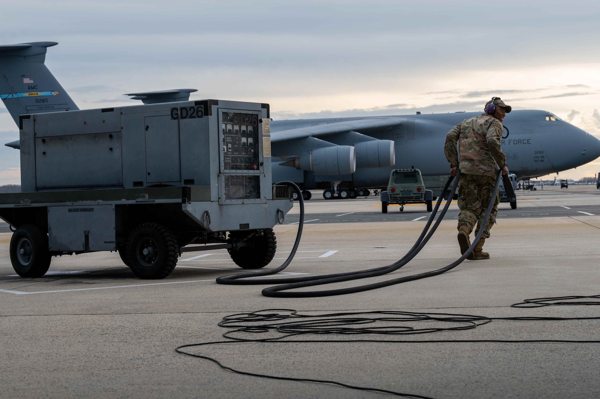 Staff Sgt. Tylur Woods, 436th Aircraft Maintenance Squadron crew chief, unplugs a power cart from a C-5M Super Galaxy before takeoff at Dover Air Force Base, Delaware, Dec. 17, 2021. The 9th Airlift Squadron delivered supplies to aid the Joint Base Pearl Harbor-Hickam (JBPHH), Hawaii water quality recovery, a joint U.S. military initiative working closely with the State of Hawaii, Department of Health, Honolulu Board of Water Supply, U.S. government and independent organizations to restore a safe water delivery system to JBPHH military housing communities through testing, treatment, and repair. For detailed information, including available resources and locations, and news, go to www.navy.mil/jointbasewater. (U.S. Air Force photo by Senior Airman Faith Schaefer)