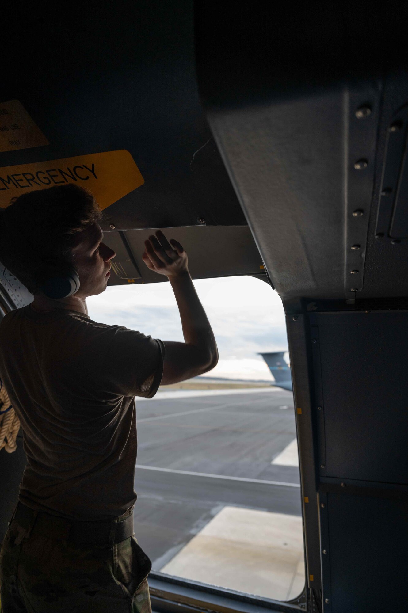 Senior Airman Evan Conway, 9th Airlift Squadron loadmaster, opens an emergency exit in the troop compartment of a C-5M Super Galaxy during pre-flight checks at Dover Air Force Base, Delaware, Dec. 17, 2021. The 9th AS delivered supplies to aid the Joint Base Pearl Harbor-Hickam, Hawaii water quality recovery, a joint U.S. military initiative working closely with the State of Hawaii, Department of Health, Honolulu Board of Water Supply, U.S. government and independent organizations to restore a safe water delivery system to JBPHH military housing communities through testing, treatment, and repair. For detailed information, including available resources and locations, and news, go to www.navy.mil/jointbasewater.      (U.S. Air Force photo by Senior Airman Faith Schaefer)