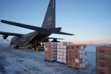 Members of the 176th Wing, Alaska Air National Guard, unload pallets of gifts from an HC-130J Combat King II aircraft Dec. 2, 2021, at Nome, Alaska, before they are loaded onto an CH-47 Chinook helicopter for delivery to Buckland as part of Operation Santa Claus 2021. This year marks the 66th year of the program.