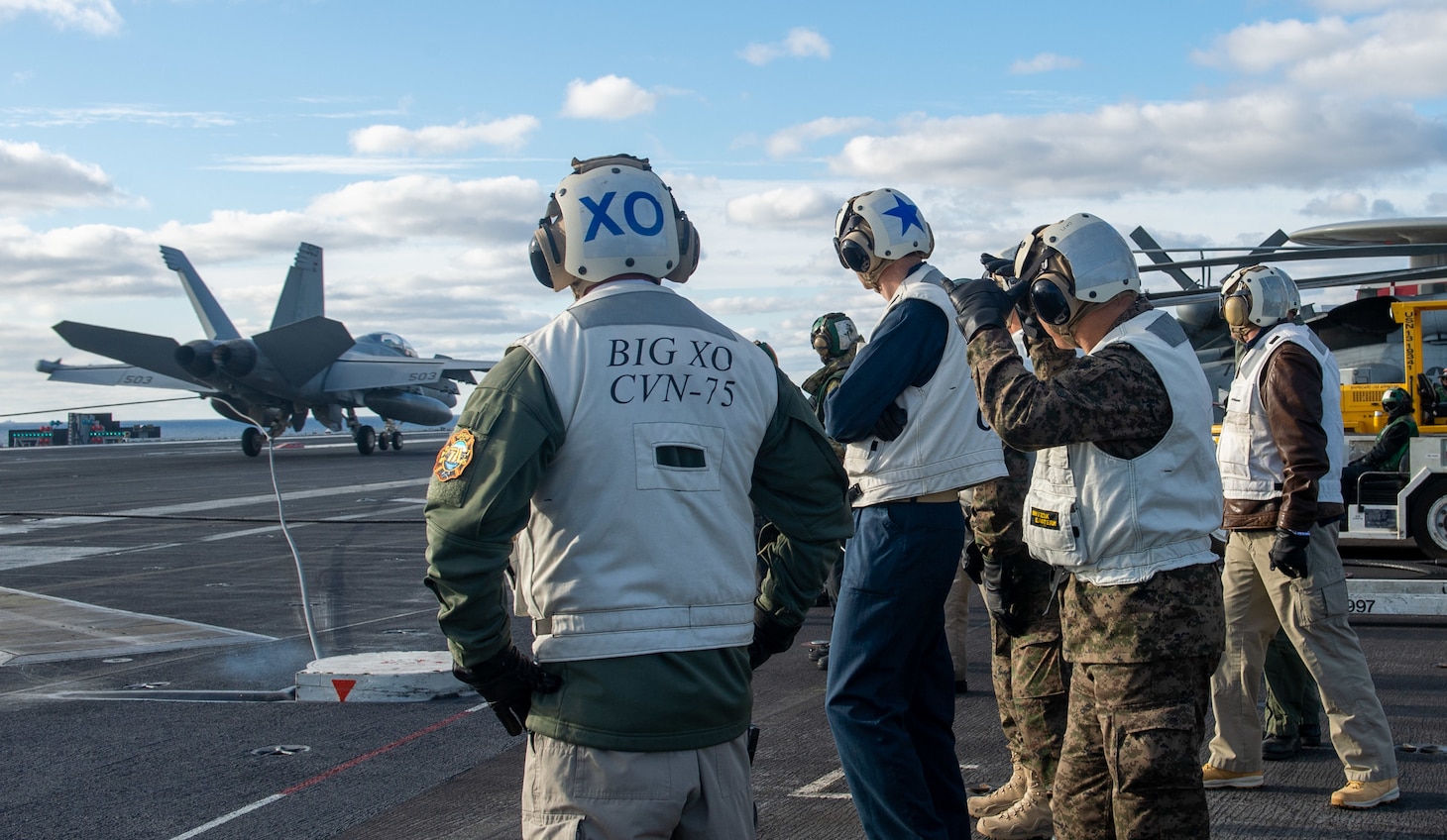 Tunisian service members, Rear Adm. Curt Renshaw, commander Carrier Strike Group Eight, and Capt. Shane Marchesi, executive officer of the Nimitz-class aircraft carrier USS Harry S. Truman (CVN 75), observe flight operations on Truman's flight deck during a distinguished visitor visit, Dec. 20, 2021.