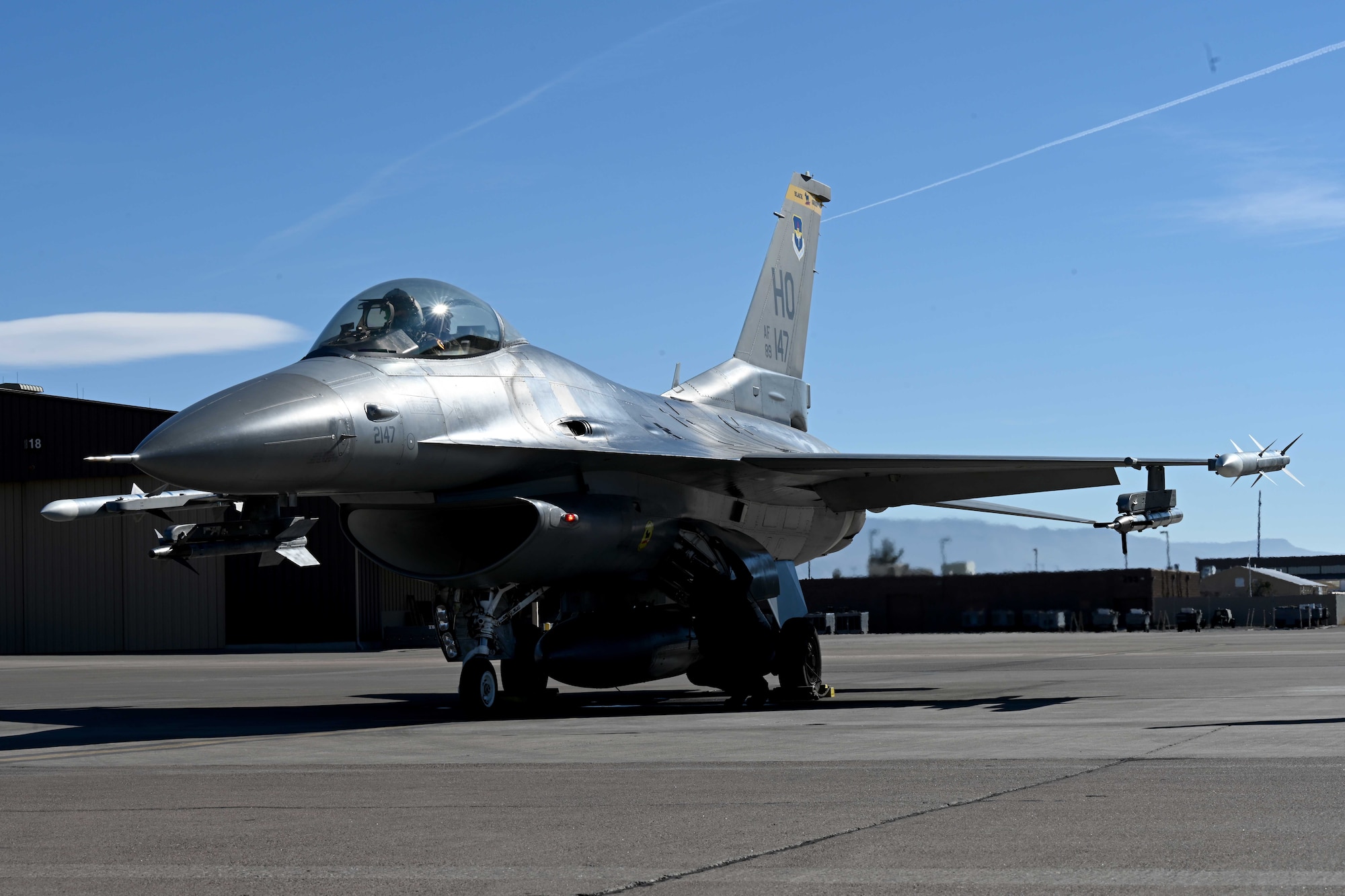 A civilian contractor, assigned to the 8th Aircraft Maintenance Unit, conducts pre-flight checks for an F-16 Viper during a transition ceremony, Dec. 22, 2021, on Holloman Air Force Base, New Mexico. Civilian contractors, previously manning the 8th AMU, ceremoniously launched an F-16 and the newly assigned 8th AMU Airmen recovered the aircraft. (U.S. Air Force photo by Staff Sgt. Christopher S. Sparks)