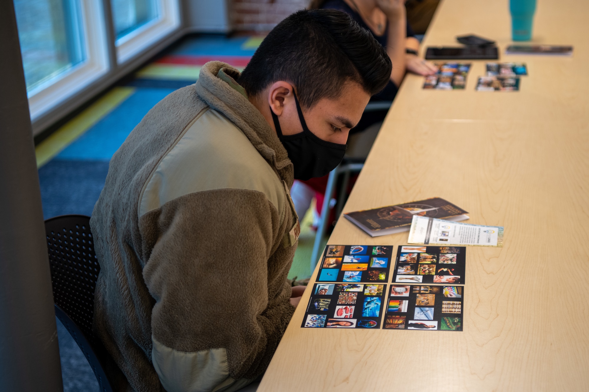Senior Airman Joshua Rodriguez, 22nd Contracting Squadron contract specialist, decides which pictures best describe his personality as part of a Four Lenses training event Dec. 23, 2021, at the Greater Wichita Partnership in downtown Wichita, Kansas.