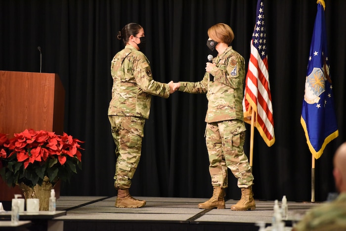 Image of an Airman shaking the hand of another Airman.