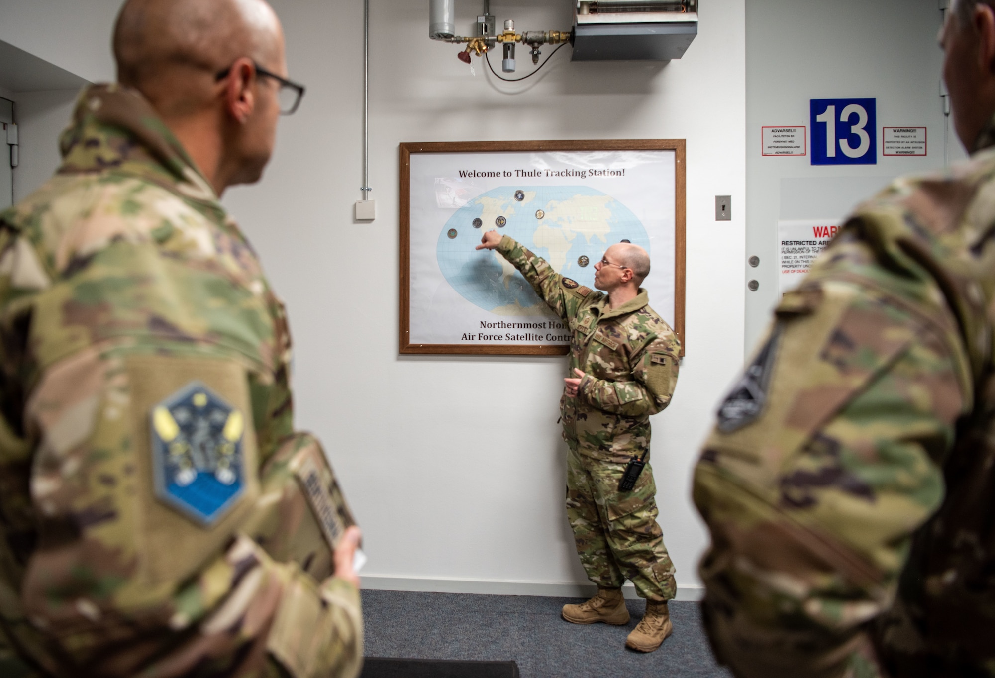 Master Sgt. John Eckert, detachment chief for the 23rd Space Operations Squadron Detachment 1, briefs Lt. Gen. Stephen N. Whiting, Space Operations Command commander, and Chief Master Sgt. John Bentivegna, SpOC senior enlisted leader, during their visit to Thule Air Base, Greenland, Dec. 17, 2021. Gen. Whiting and the SpOC command team traveled to Thule to meet with Airmen and Guardians from the 821st Air Base Group, 23 SOPS, and the 12th Space Warning Squadron to gain a better understanding of their current challenges and successes as Department of Defense’s northernmost installation located 750 miles north of the Arctic Circle and only 947 miles south of the North Pole. Other areas discussed throughout the visit include initiatives to improve Thule’s Air Force Research Laboratory, Low-Earth Orbit, Starlink terminals, Communications Satellite upgrades, and support for U.S. Northern Command events in the Arctic. (U.S. Space Force photo by Master Sgt. Sara Keller)