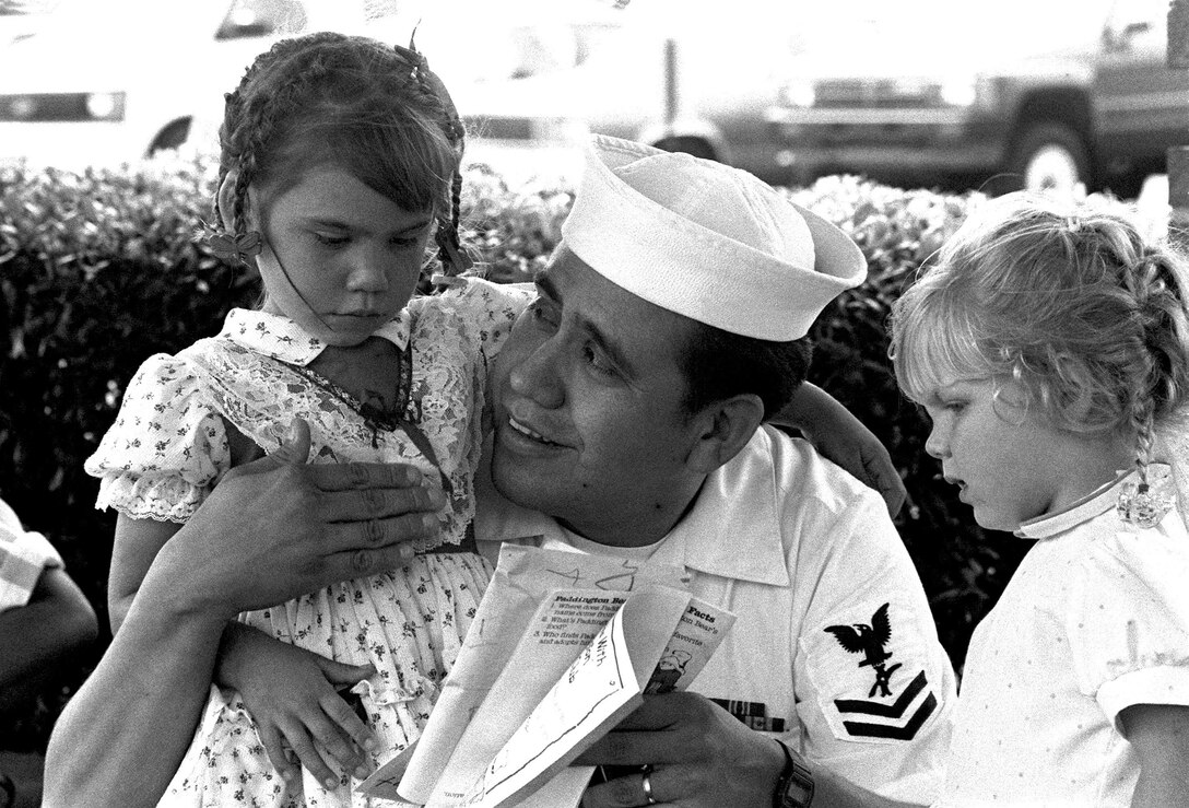 Legalman 2nd Class Manuel Ganoa smiles proudly at his four-year-old daughter, upon her graduation from the Naval Air Station Pensacola Library's Summer Reading Program, Aug. 1, 1989.