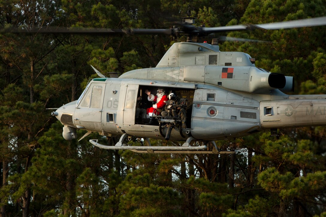 Santa Claus waves from a Marine Corps helicopter.