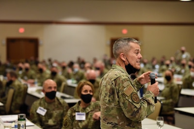 Image of an Airman speaking to a crowd.