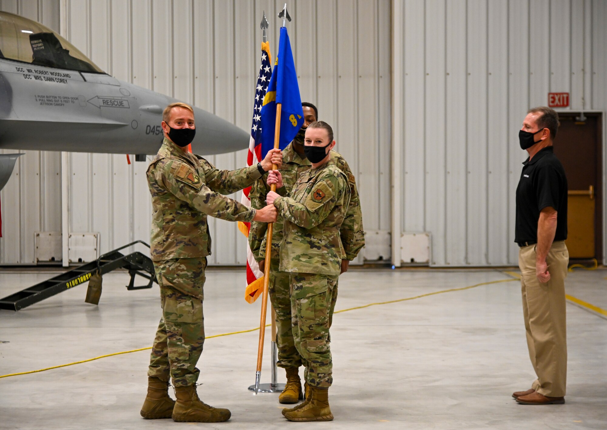 Capt. Amanda Cyphers, 8th Aircraft Maintenance Unit officer in charge, receives the guidon from Col. Thomas Preston, 49th Maintenance Group commander, during the 8th AMU transition ceremony, Dec. 22, 2021, on Holloman Air Force Base, New Mexico. This is the first time since the 8th AMU’s reactivation in 2017, that the AMU will be manned by active duty members. (U.S. Air Force photo by Airman 1st Class Jessica Sanchez-Chen)