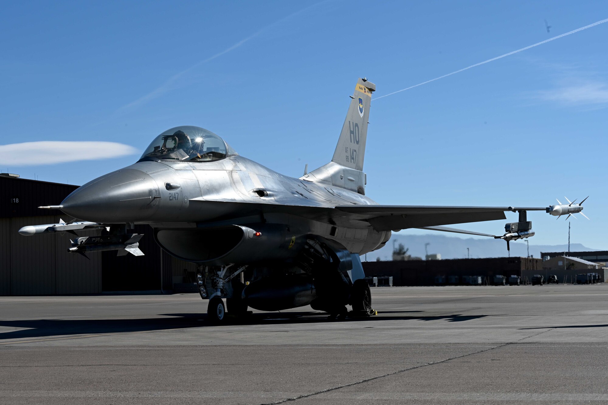 A civilian contractor, assigned to the 8th Aircraft Maintenance Unit, conducts pre-flight checks for an F-16 Viper during a transition ceremony, Dec. 22, 2021, on Holloman Air Force Base, New Mexico. Civilian contractors, previously manning the 8th AMU, ceremoniously launched an F-16 and the newly assigned 8th AMU Airmen recovered the aircraft. (U.S. Air Force photo by Staff Sgt. Christopher S. Sparks)