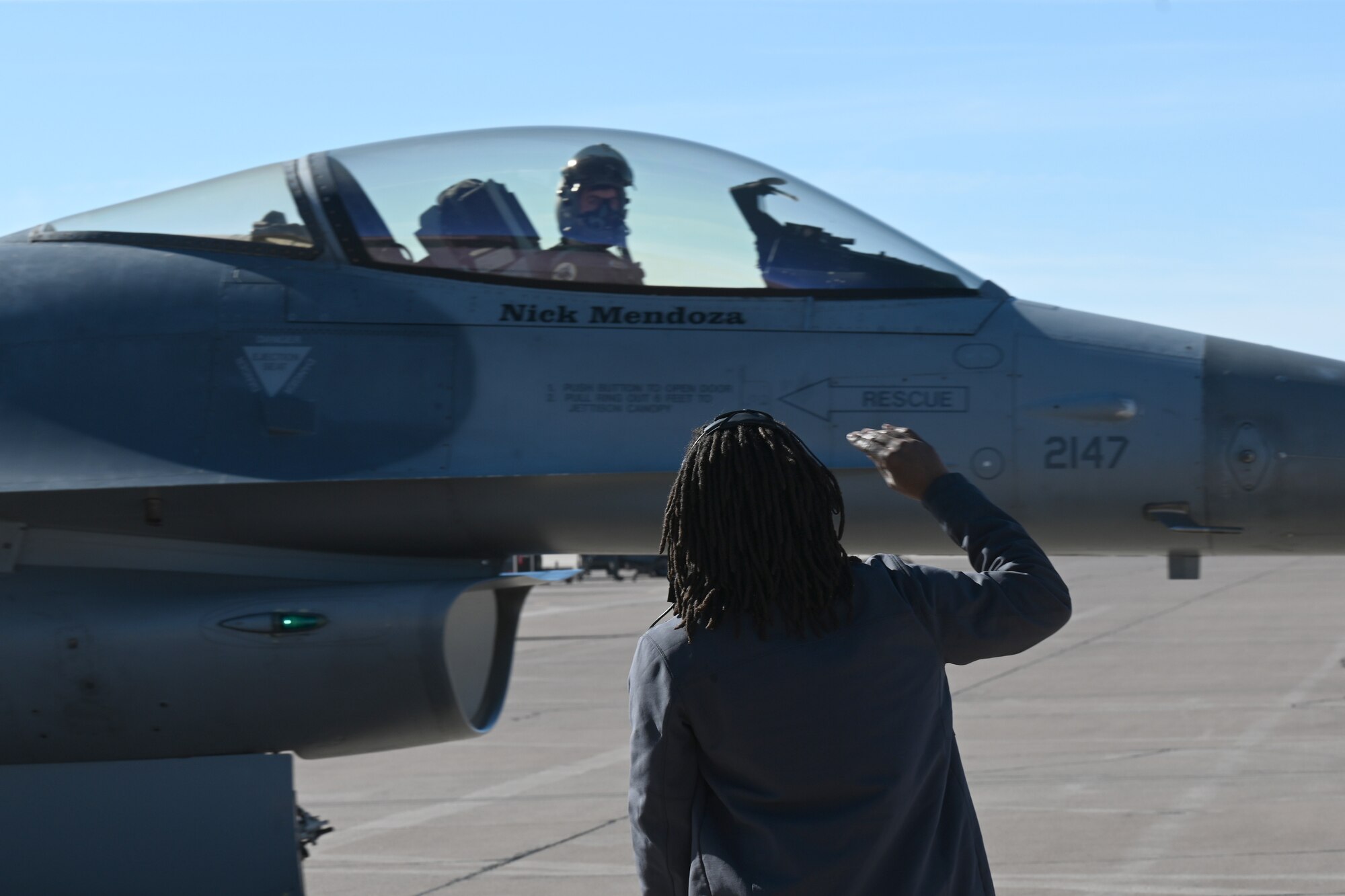 A civilian contractor, assigned to the 8th Aircraft Maintenance Unit, renders a salute to an F-16 Viper pilot, Dec. 22, 2021, on Holloman Air Force Base, New Mexico. This marked the final time a civilian contractor will launch an 8th Fighter Squadron F-16 as the primary crew chiefs for the 8th AMU. (U.S. Air Force photo by Staff Sgt. Christopher S. Sparks)