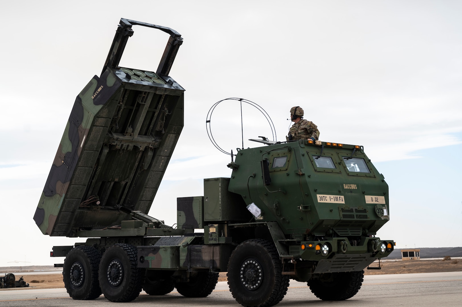 A soldier stands in a high mobility artillery rocket system.
