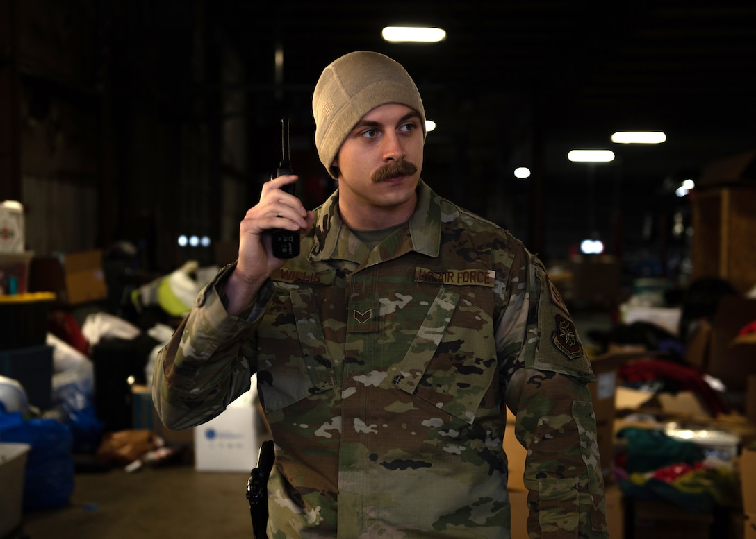 Senior Airman Tristan Willis, a defender with the Kentucky Air National Guard’s 123rd Security Forces Squadron, monitors the Mayfield Police Department radio feed during a presence patrol in Mayfield, Ky., Dec. 18, 2021. Willis and 16 other security forces Airmen mobilized from Louisville, Ky., to augment the Mayfield Police Department following a Category 5 tornado that leveled much of the town. (U.S. Air National Guard photo by Staff Sgt. Clayton Wear)