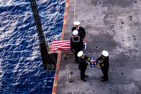 Sailors commit cremains to the deep during a burial-at-sea aboard the Nimitz-class aircraft carrier USS Harry S. Truman (CVN 75), Dec. 11, 2021.