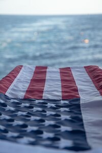 American flag lays atop a catafalque during a burial at sea aboard the Nimitz-class aircraft carrier USS Harry S. Truman (CVN 75), Dec. 11, 2021.