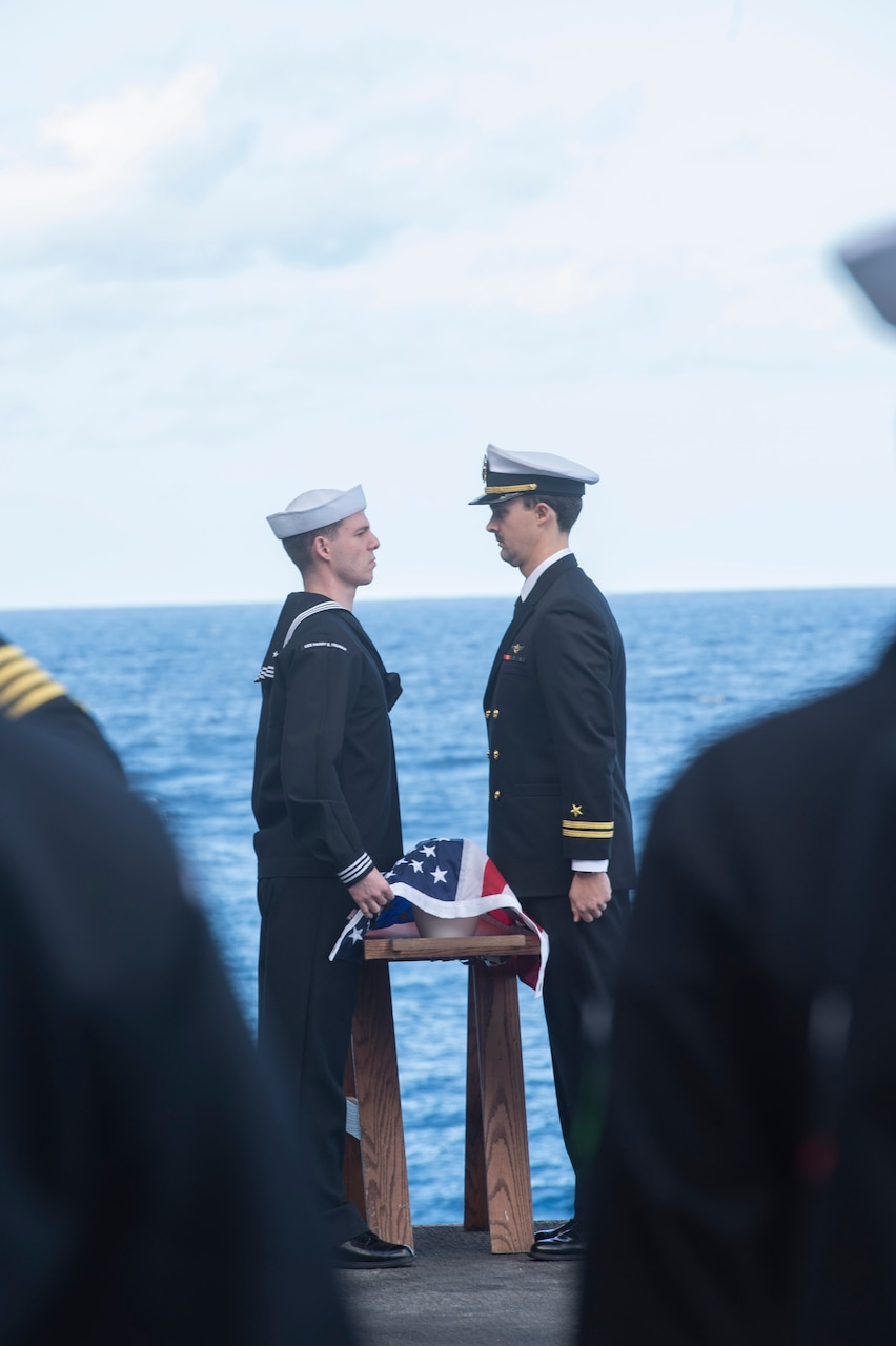 Sailors commit cremains to the deep during a burial-at-sea aboard the aircraft carrier USS Harry S. Truman (CVN 75), Dec. 11, 2021.