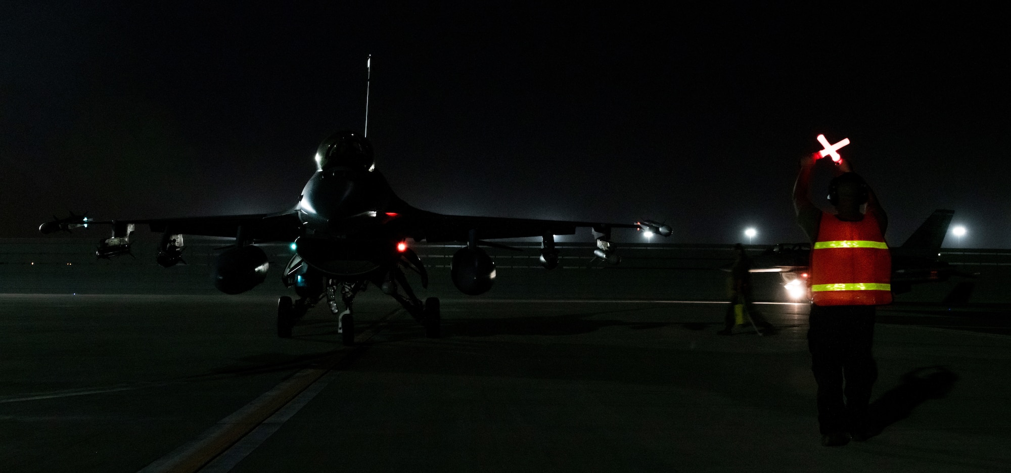 Military member taxis in a jet on the flight line.