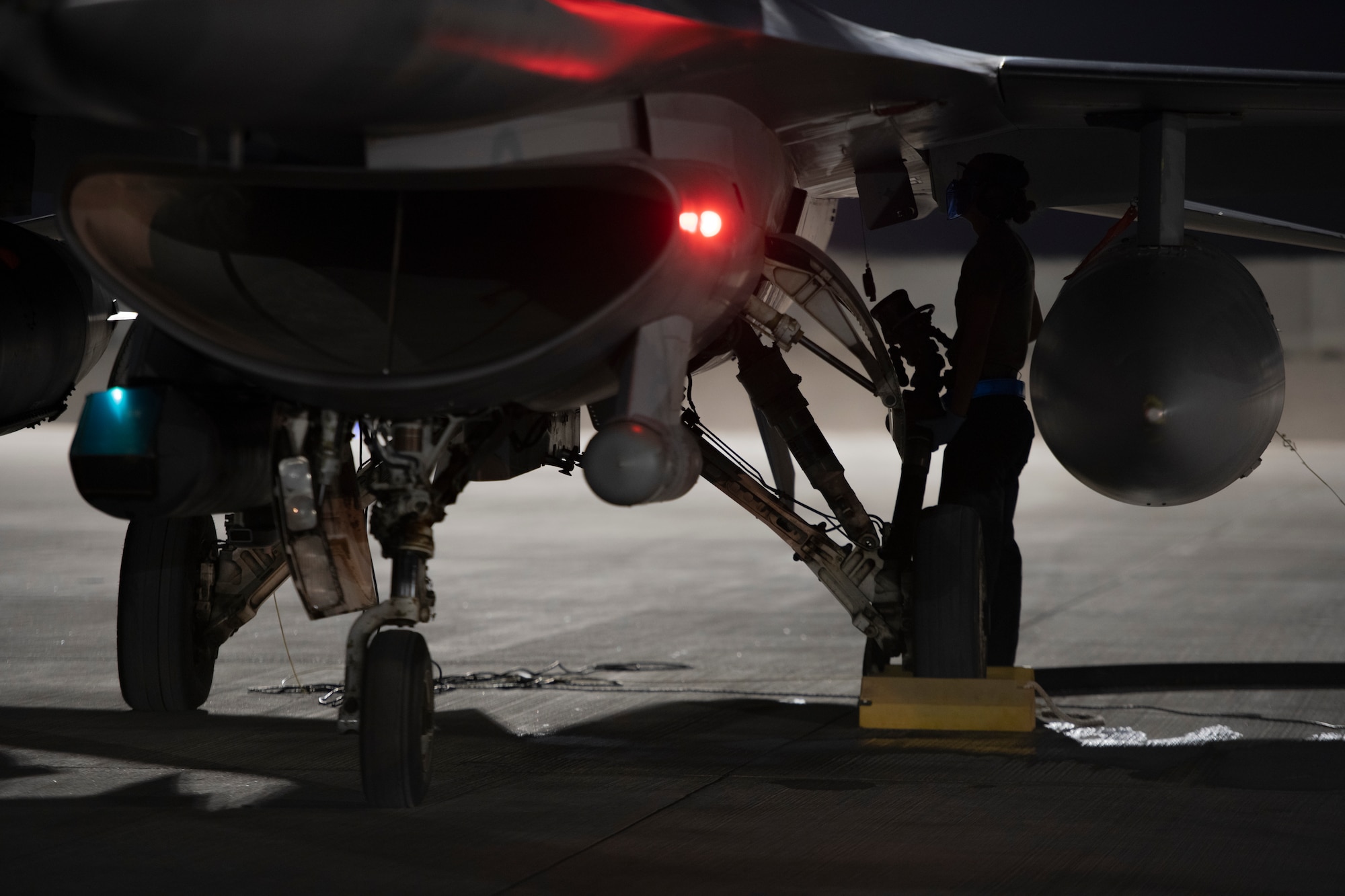 Airmen attaches fuel nozzle to airplane.