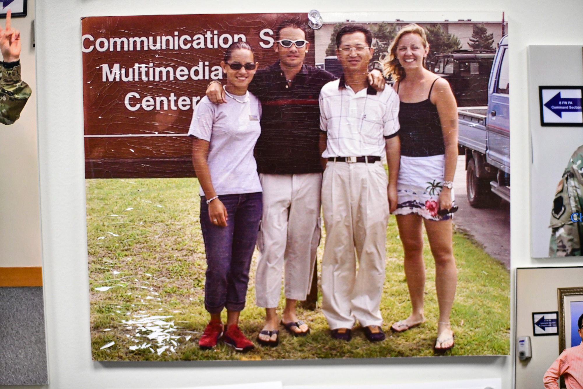 A graphics technician takes a photo with his coworkers.