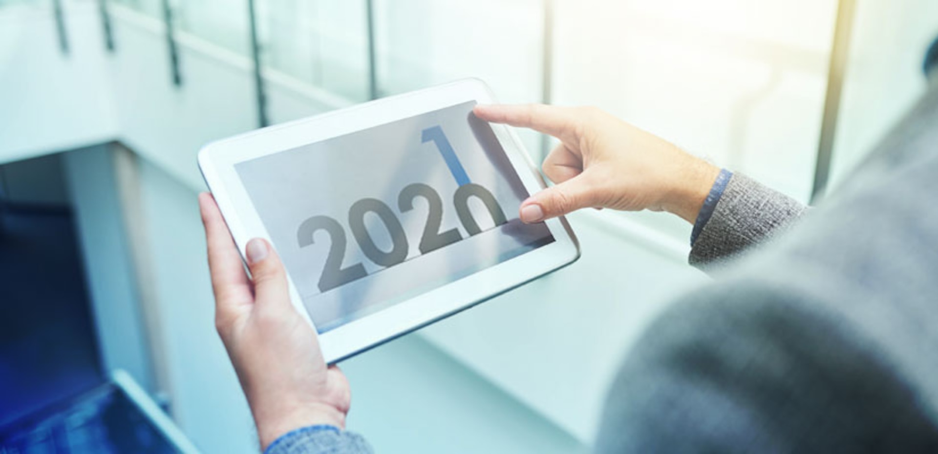 Hands holding a tablet with number changing from 2020 to 2021