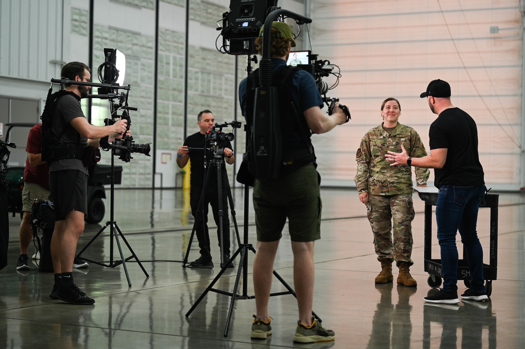 Staff Sgt. Sarah Gettings,15th Maintenance Squadron aircraft structural maintenance journeyman, explains the importance of supporting the longevity of the C-17 Globemaster III to Cody Alan, Country Music Television Radio host and executive producer, while filming for CMT’s Hot 20 Annual Holiday Salute to the Troops at Joint Base Pearl Harbor-Hickam, Hawaii, Nov. 29, 2021. Airmen assigned to the 15th MXS, 15th Aerospace Maintenance Squadron, the 535th Airlift Squadron and members from the Hawaii Air National Guard showcased their ability to support the C-17 and KC-135 Stratotanker missions. (U.S. Air Force photo by Staff Sgt. Alan Ricker)