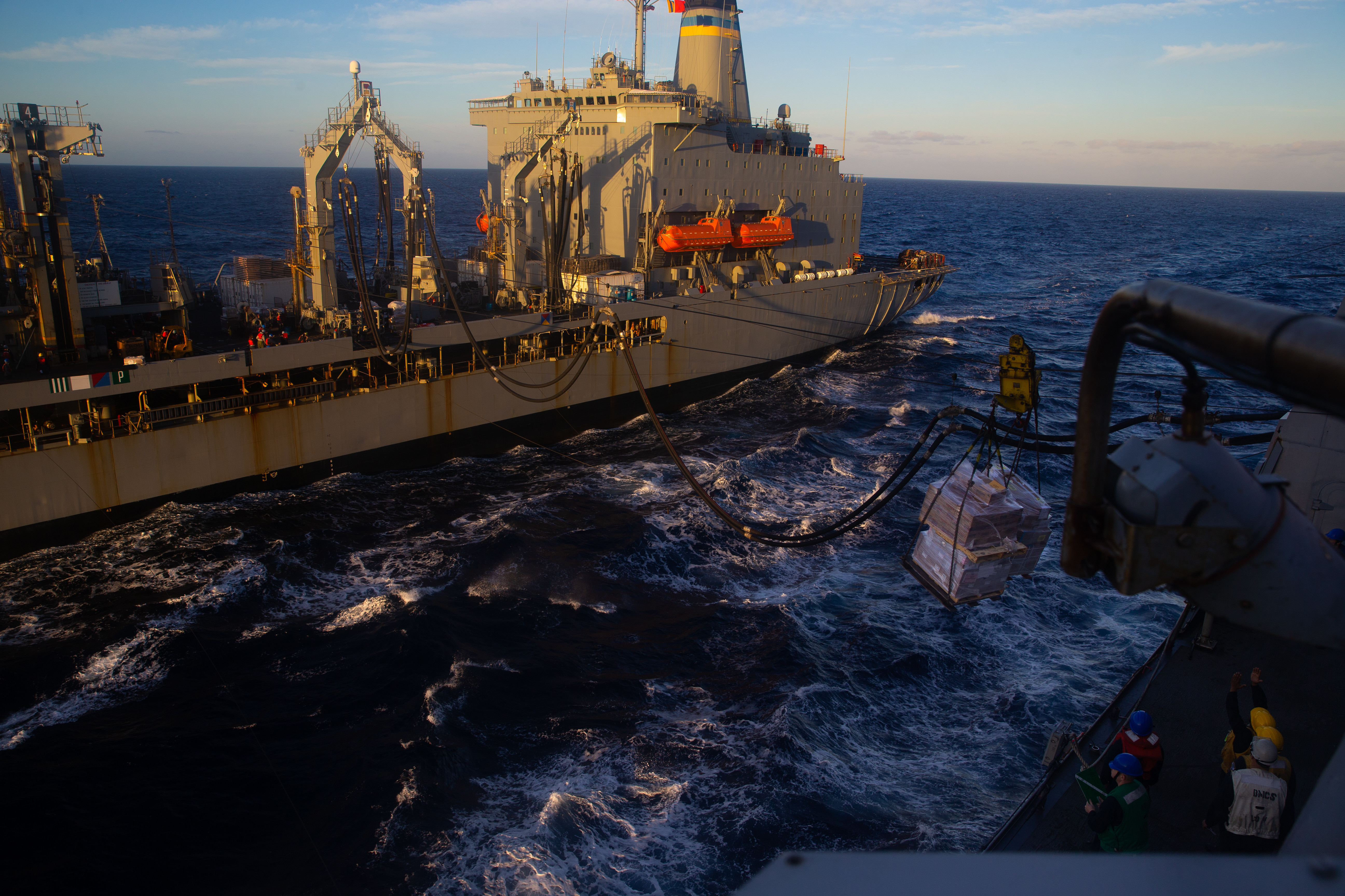 The Henry J. Kaiser-class replenishment oiler USNS Leroy Grumman (T-AO-195) delivers supplies to the amphibious transport dock ship USS Arlington (LPD 24) during a replenishment at sea (RAS).