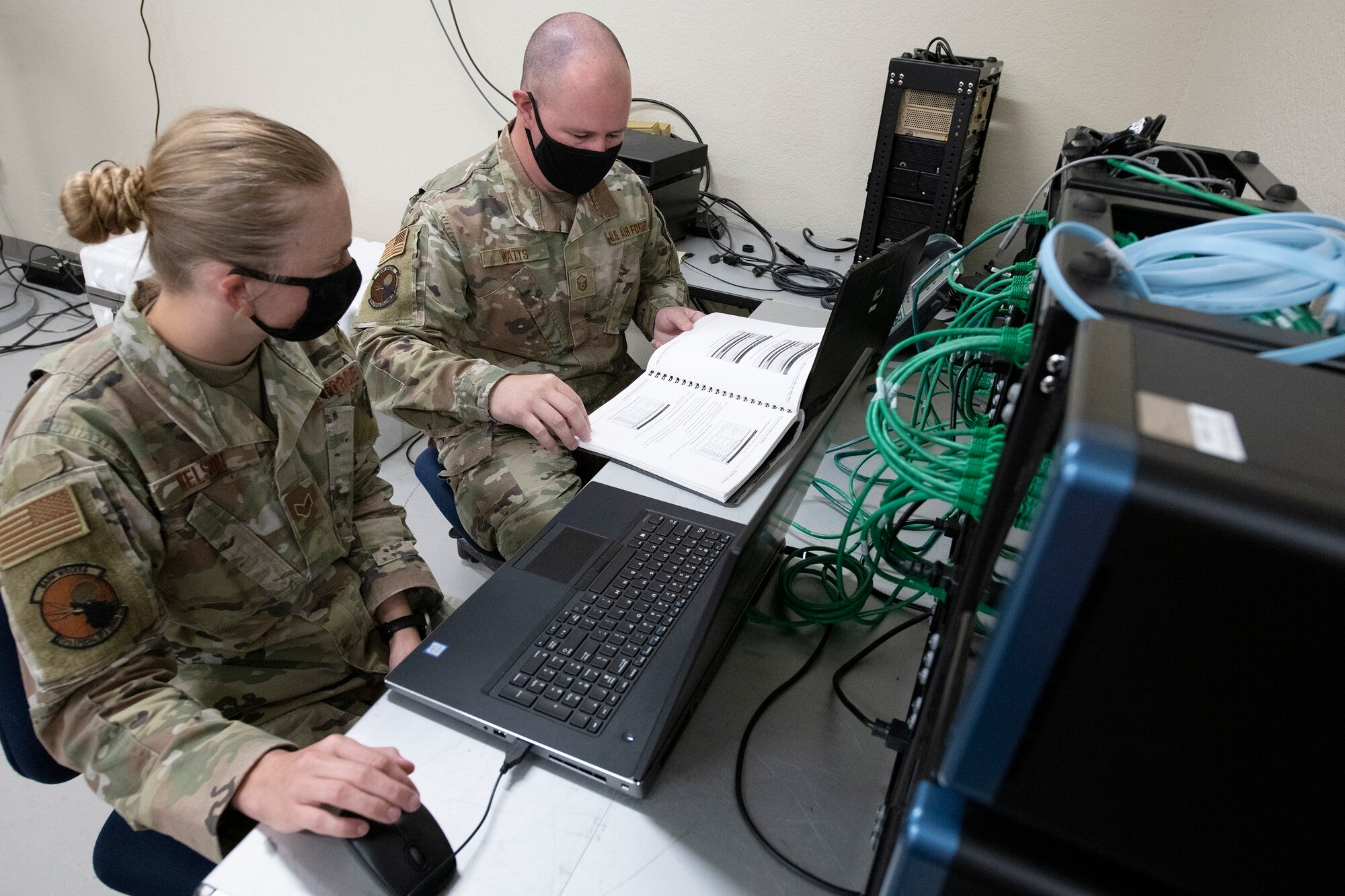 Cyber technicians sit at a desk next to communication network system