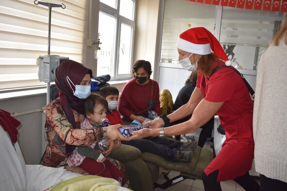 woman giving toys to children in hospital