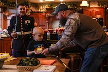 Gunner Sadler passes his piece of cake to his father Ryan Sadler in their home in Bloomington, Ill. on Dec. 18. The Marine Corps coordinated with the Saddler family to conduct the ceremony in honor of Gunners strength and tenacity as he faces the road forward, guided by the Make-A-Wish foundation. Ryan is a Marine Corps veteran who wanted to share a Marine Corps tradition with his son.  (U.S. Marine Corps photo by Lance Cpl. Tyler M. Solak)