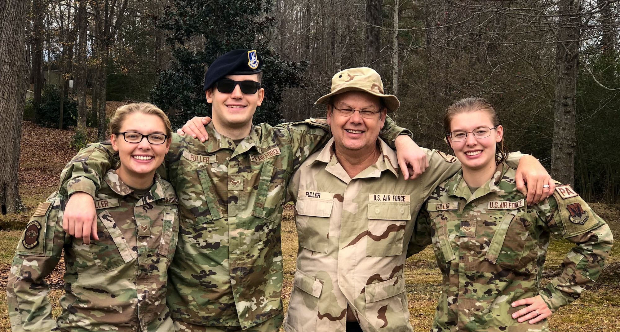 Senior Airman Selina Fuller, left, 68th Rescue Squadron rescue intelligence analyst, Airman 1st Class Sven Fuller, 4th Security Forces entry controller and Airman 1st Class Sabrina Fuller, 4th Fighter Wing public affairs specialist, pose for a photo with their father retired Air Force Master Sergeant Kent Fuller in Ashville, North Carolina, December 21, 2021.