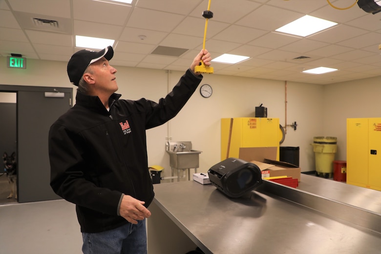 Wayne Foster, COR Construction Inspection, USACE, Omaha District extends the electrical cords in the new firing range, weapons cleaning and storage area. Minot Air Force Base, North Dakota, December 15, 2021.