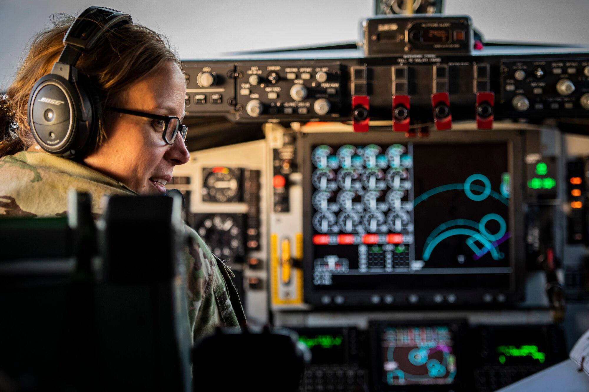 Female service member looks over her shoulder at co-pilot