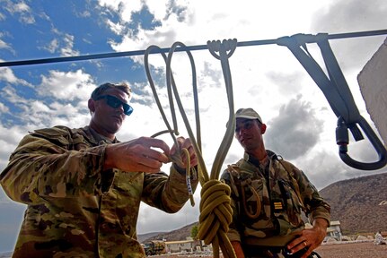 U.S. Army Sgt. Charles Riczu, a Connecticut Army National Guard Soldier, currently deployed with the 1-102nd Infantry Regiment (Mountain), Task Force Iron Gray, demonstrates military mountaineering skills to French Marine Capt. Benoit Malet, the officer in charge of the French Desert Commando Course, during the Joint Expeditionary Mountain Warfare Course.