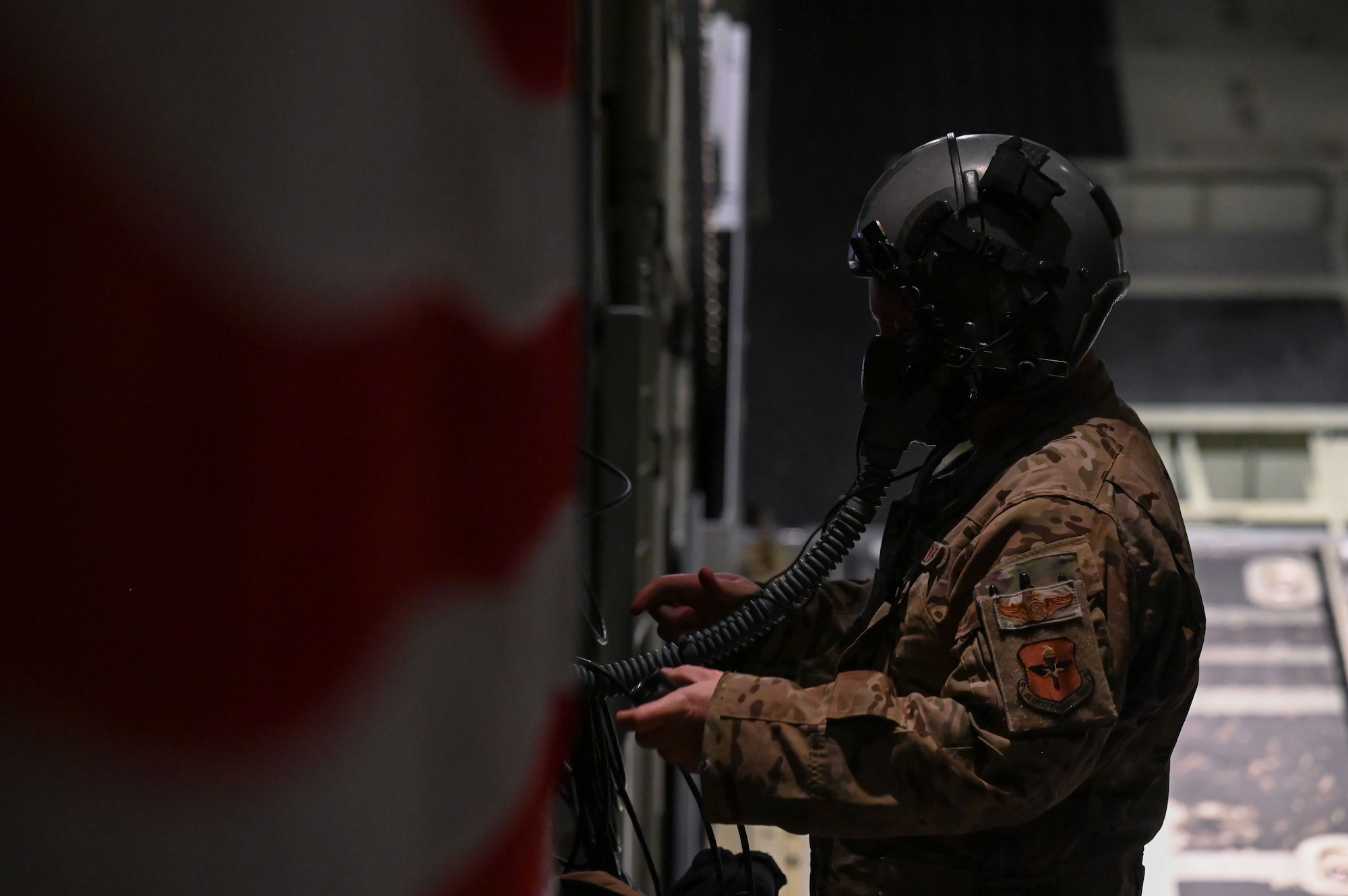 A loadmaster conducts pre-flight checks of his gear.