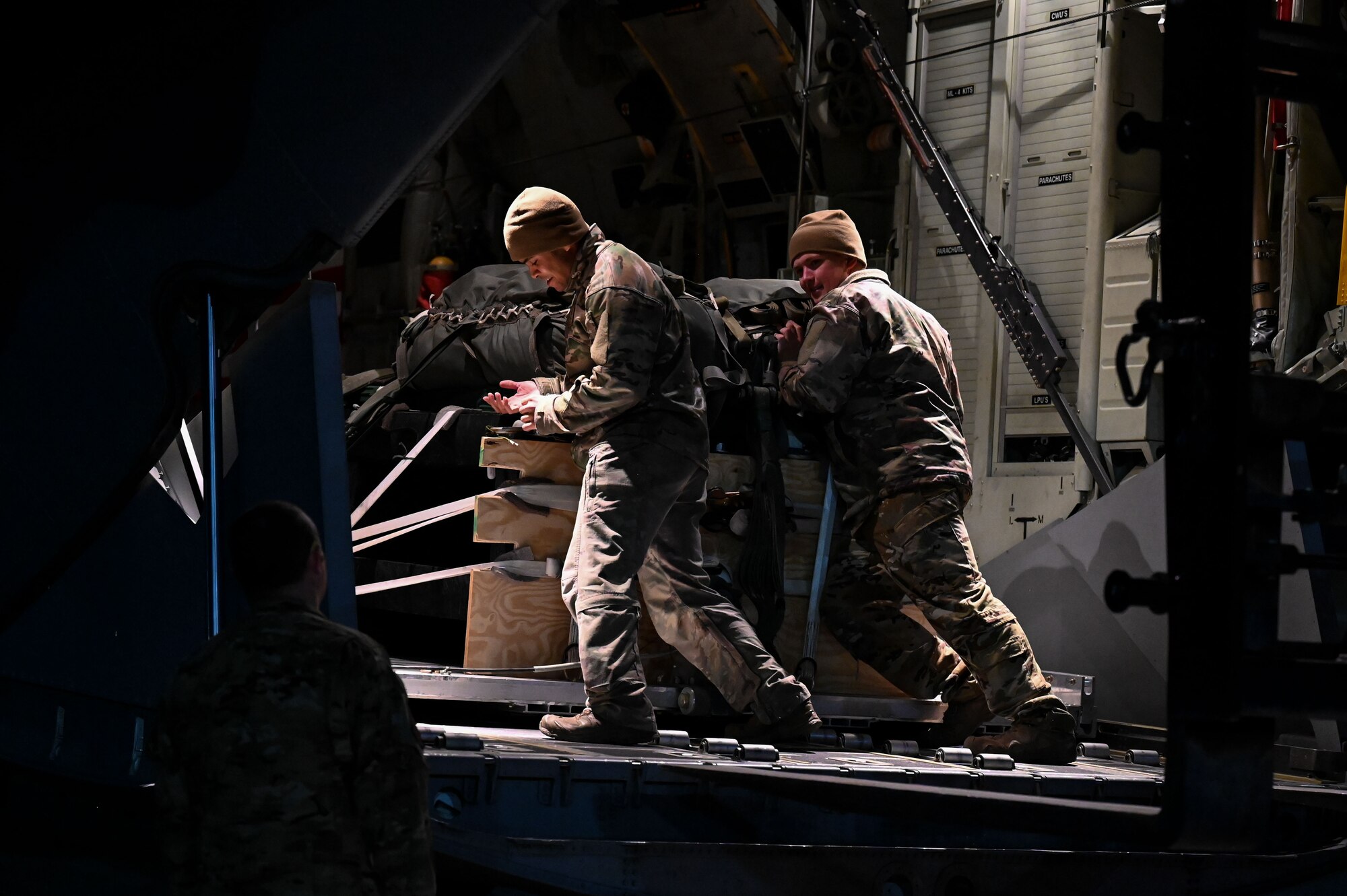 Loadmasters load cargo onto an aircraft