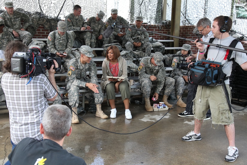 A woman visits with troops.