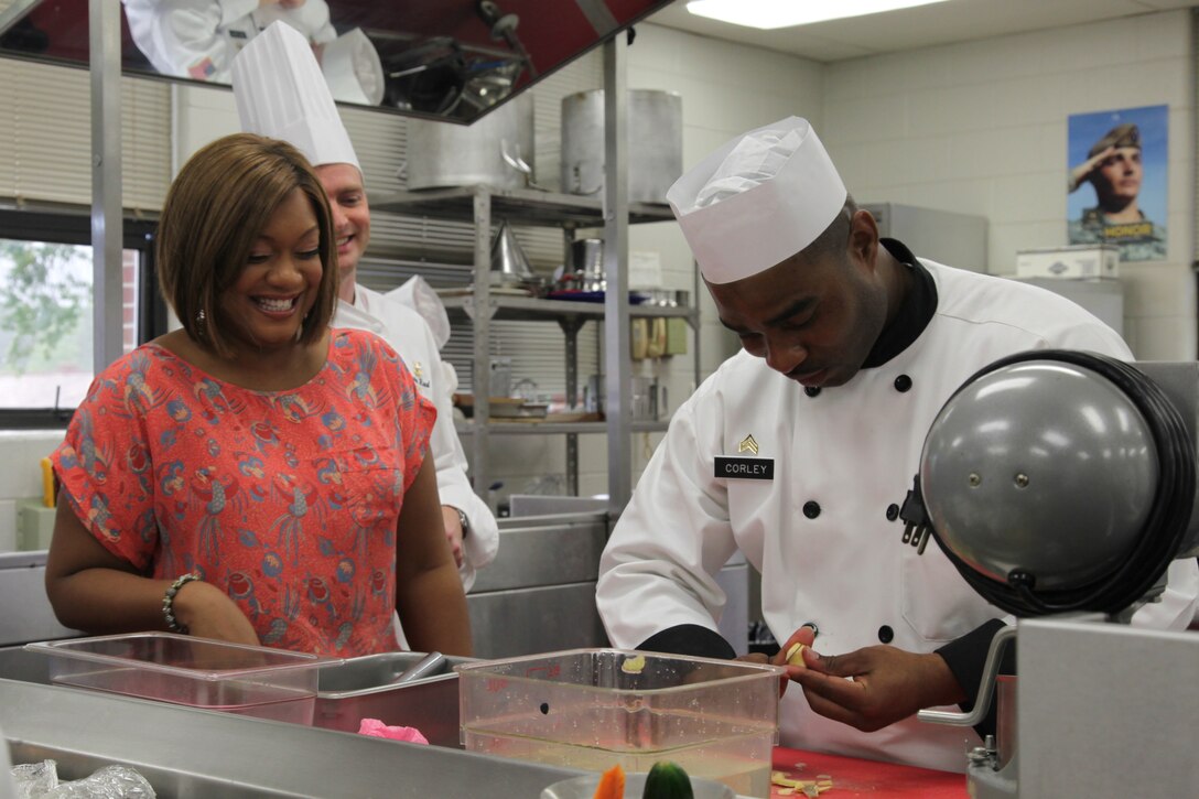 A woman chats with a chef.